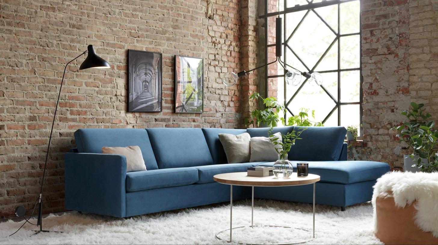 Sofá modular Sits en un espacio tipo loft con ladrillo visto y ventanal industrial, zona lounge para oficinas y coworking